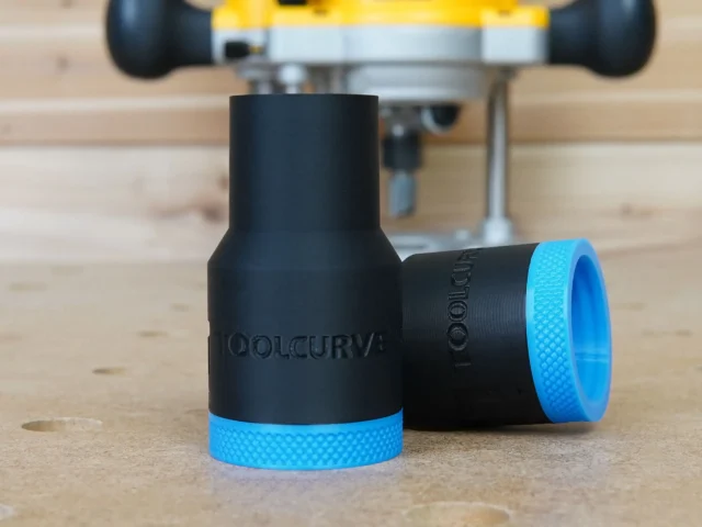 Black plastic hose adapter with blue grip rings at each end, labeled ToolCurve, shown on wooden workbench with Dewalt router in background