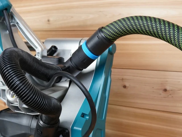 Black hose adapter with blue collar attached to Makita miter saw dust collection port, with black and lime green braided hose connected