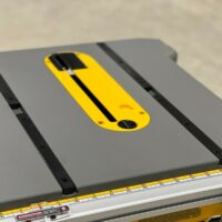 Yellow miter bar with black slot installed on a Dewalt table saw alongside the miter slot
