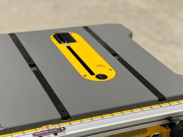 Yellow miter bar with black slot installed on a Dewalt table saw alongside the miter slot
