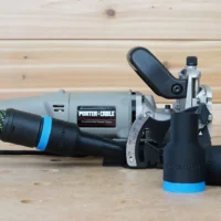 Black and blue hose adapter attached to a Porter Cable 557 plate joiner, with a dust extractor hose connected to the adapter port