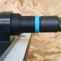 Black hose adapter with blue band attached to router table dust port, connected to green and black hose