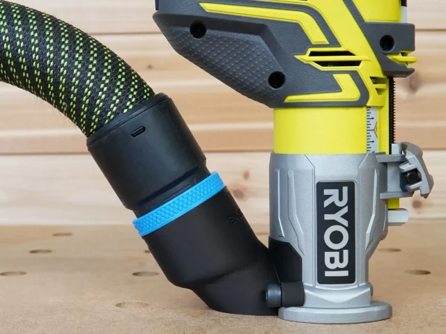Hose adapter attached to Ryobi trim router with 36mm hose connected, blue band visible on black adapter sleeve