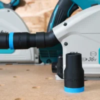 Black ToolCurve hose adapter with blue collar standing upright beside a Makita track saw, a second adapter linking a hose to the saw's dust port