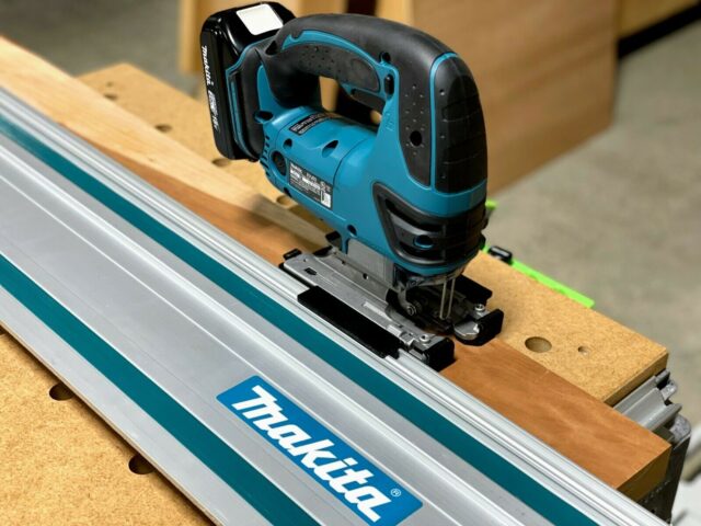 Makita jigsaw with blue adapter plate mounted on Makita track saw guide rail, showing snap-on connection