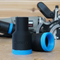 Two black stepped hose adapters with blue ribbed collars standing on a bench, Porter Cable 557 plate joiner behind