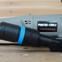 Black hose adapter with blue band attached to Porter Cable plate joiner 557, connected to braided green hose