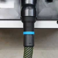 Black ToolCurve hose adapter with blue grip band attached to router table 2 1/4 inch dust port, green and black Festool hose connected below