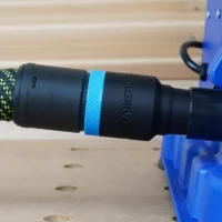 Black hose adapter with blue band attached to Kreg foreman pocket-hole machine, braided hose connected to adapter port