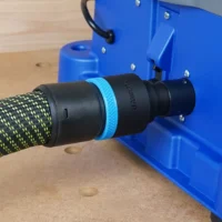 Black 36mm hose adapter with blue ring joining a braided extractor hose to the blue Kreg Foreman rear dust port