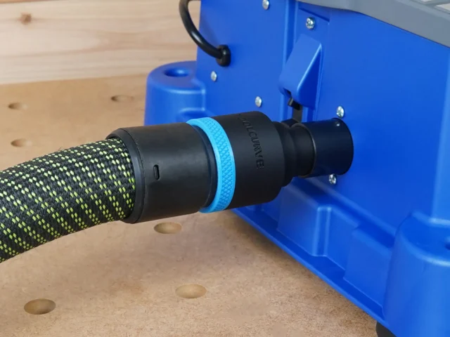 Black 36mm hose adapter with blue ring joining a braided extractor hose to the blue Kreg Foreman rear dust port