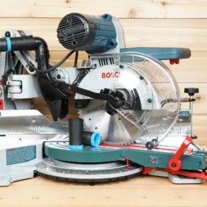 Black ToolCurve hose adapter with blue collar resting on a Bosch 10-inch glide miter saw table, hose fitted at rear port