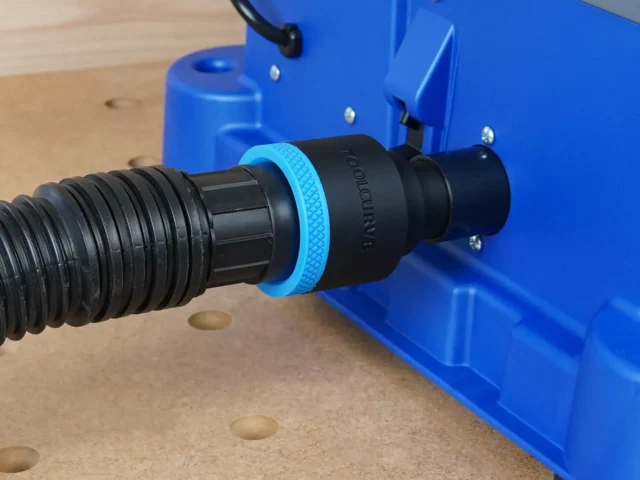Black ToolCurve 1-7/8 inch hose adapter with blue collar joining a vacuum hose to the blue Kreg Foreman rear dust port