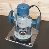 10-inch square clear acrylic router base plate attached to a Bosch 1617 plunge router