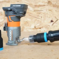 ToolCurve hose adapter for Ridgid trim router connected to orange and black 1 1/4-inch hose with matching adapter sleeve