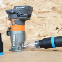 Black ToolCurve hose adapter with blue band connecting a vacuum hose to a Ridgid trim router's clear dust port