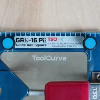TSO Guide Rail Square anti-tip support tab in blue with bright cyan mounting knobs, labeled GRS-16 PE, shown from top view on wooden surface