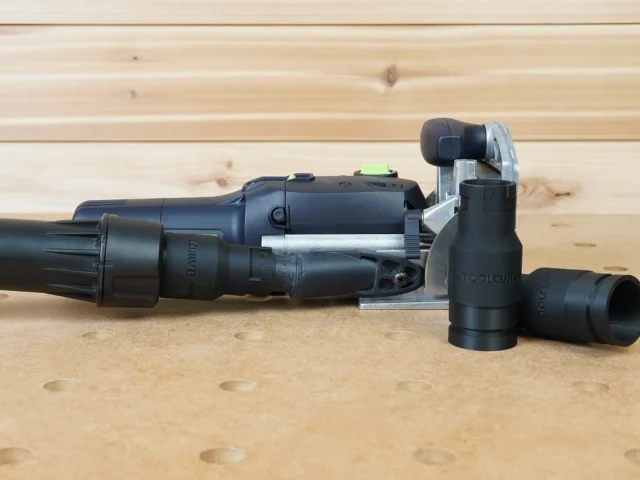 Black ToolCurve Dewalt quick-connect hose adapter fitted to a Festool tool's dust port, with two spare adapters alongside