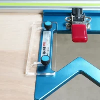 TSO guide rail square anti-tip support tab mounted on blue aluminum rail, with red clamp and acrylic support visible