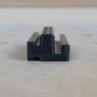 Black plastic rail square holder with dual slots, designed to mount on the side of an MFT/3 table t-track