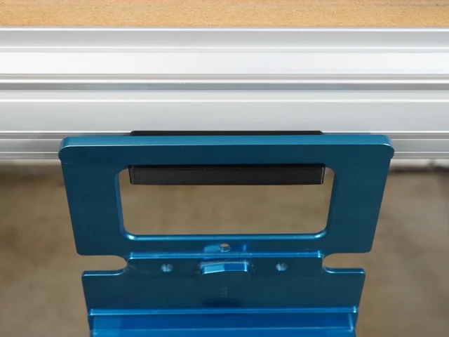 Blue plastic holder mounted on MFT/3 table t-track with black guide rail square stored vertically inside