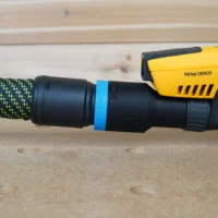 Hose adapter with blue band attached to Mirka Deros sander, connected to green braided hose