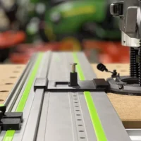 Skil RT1322 plunge router adapter mounted on Festool track rail with LR32 plate, spring-loaded knob, and guide rail stops for hole drilling