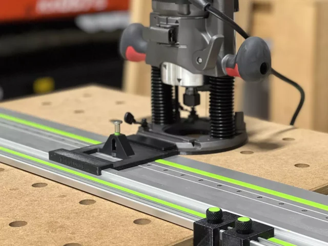 Skil RT1322 plunge router mounted on LR32 guide rail with hole drilling adapter and positioning stops on wood workbench