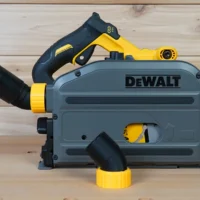 No Snag Dust Port Adapter attached to a DeWalt track saw, with black hose angled upward and yellow twist-lock connector visible