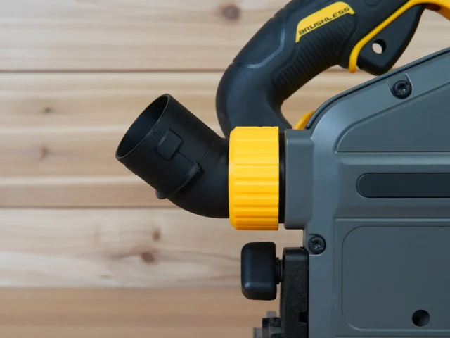 No Snag Dust Port adapter installed on a DeWalt track saw, showing the yellow hose connector angled upward and away from the saw base