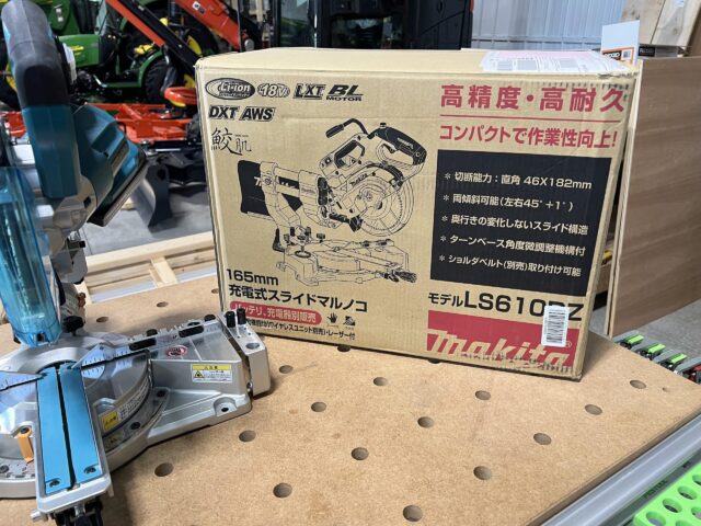 Makita LS610DZ miter saw in original Japanese packaging, shown in cardboard box next to base unit on work table