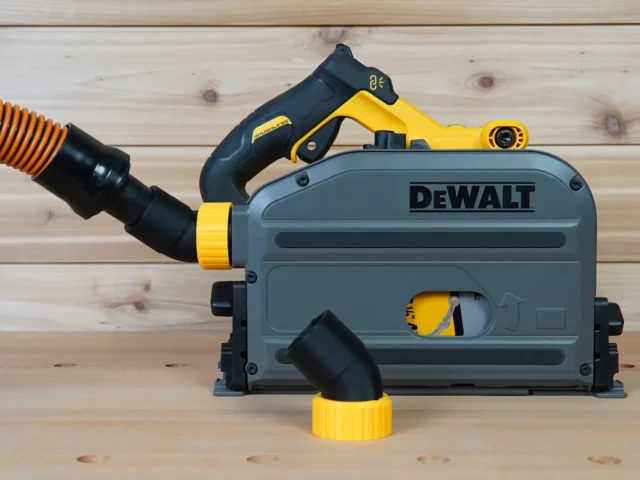 No Snag Dust Port Adapter attached to a DeWalt track saw, with yellow and black hose fittings angled upward to direct dust extraction away from the cutting area