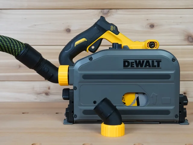 No Snag Dust Port adapter installed on a Dewalt track saw, with yellow and black hose adapter attached and vacuum hose routed upward
