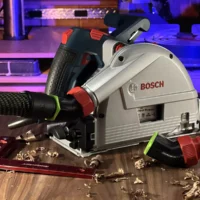No Snag Dust Port adapter attached to a Bosch track saw, angling the hose upward away from the work surface