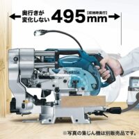 Makita LS610DZ miter saw mounted on workbench with extension arms extended 495mm, held by operator's hand