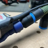 Black hose adapter with blue bands installed on a SurfPrep sander, showing the 27mm port and threaded connection