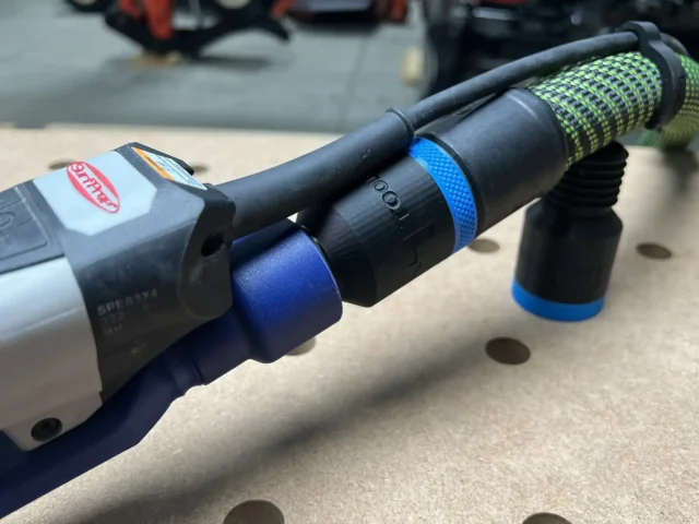 Black hose adapter with blue bands installed on a SurfPrep sander, showing the 27mm port and threaded connection