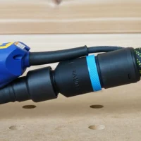 Black hose adapter with blue band attached to Ekasand sander rear dust port, connected to 27mm European hose