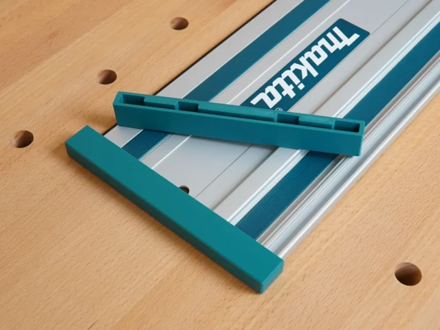 Teal protective caps mounted on each end of a Makita track saw rail