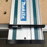 Black protective caps installed on both ends of a Makita aluminum guide rail