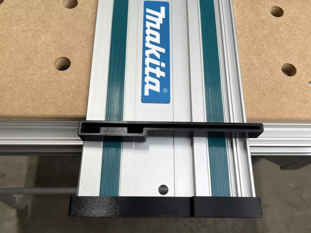 Black protective caps installed on both ends of a Makita aluminum guide rail