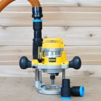 Black 1-1/4 inch hose adapter with blue ring linking an orange hose to a DeWalt plunge router dust port