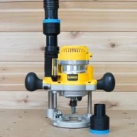 Black ToolCurve 1-7/8 inch hose adapter with blue band beside a DeWalt plunge router linked to a vac hose