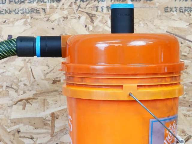 Two black 36mm hose adapters with blue rings on a Dustopper cyclone separator, one joined to a vac hose