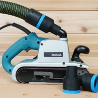 Black 36mm hose adapter with blue ring joining a Festool hose to a Makita 9403 belt sander, plus a spare adapter