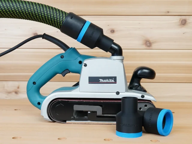 Black 36mm hose adapter with blue ring joining a Festool hose to a Makita 9403 belt sander, plus a spare adapter