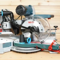 Black ToolCurve 1-7/8 inch hose adapter with blue collar resting on a Bosch 10-inch glide miter saw table