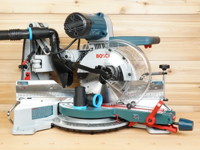 Black ToolCurve 1-7/8 inch hose adapter with blue collar resting on a Bosch 10-inch glide miter saw table