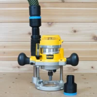 Black 36mm hose adapter with blue band on a DeWalt plunge router dust port, second adapter beside it