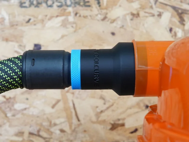 Black hose adapter with blue band attached to orange Dustopper cyclone separator and green-and-black braided hose